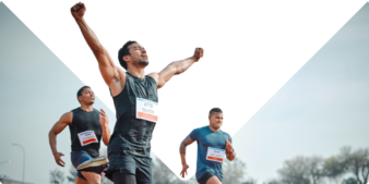 Men in a race as one crosses the finish line